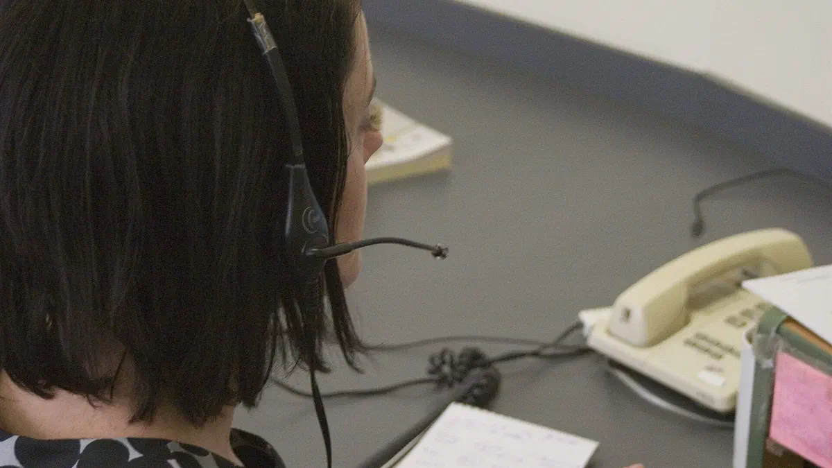 Employée portant un casque téléphonique à son poste de travail