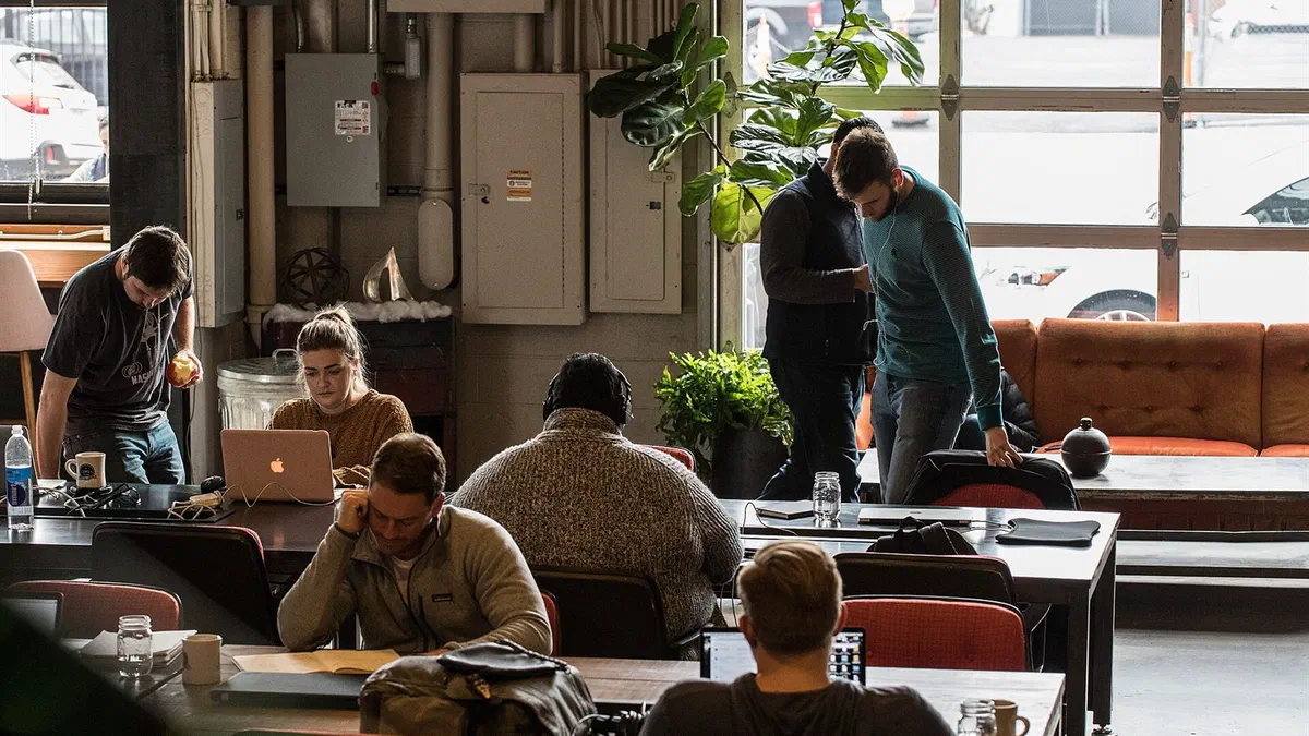 Personnes travaillant sur des ordinateurs portables dans un espace de coworking